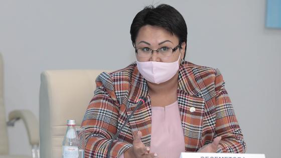 Женщина в костюме сидит за столом Женщина в костюме сидит за столом