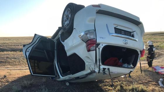 Опрокинувшийся внедорожник марки Toyota лежит на земле Опрокинувшийся внедорожник марки Toyota лежит на земле
