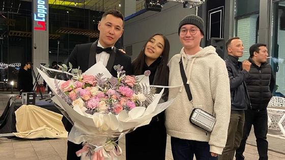 Шарип Серик и певица Say Mo стоят с букетом цветов Шарип Серик и певица Say Mo стоят с букетом цветов