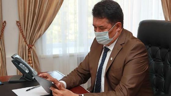 Ержан Иманслям сидит за столом Ержан Иманслям сидит за столом