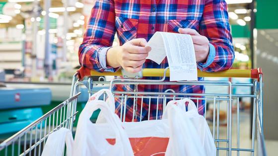 Женщина смотрит в чек в магазине Женщина смотрит в чек в магазине