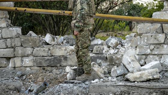 Военный стоит у разрушенной стены Военный стоит у разрушенной стены
