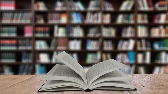 раскрытая книга на фоне библиотеки раскрытая книга на фоне библиотеки