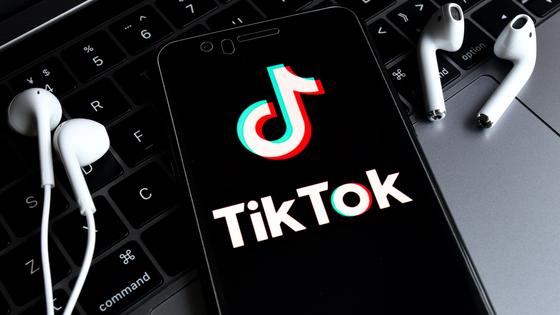 Смартфон лежит на клавиатуре с наушниками Смартфон лежит на клавиатуре с наушниками
