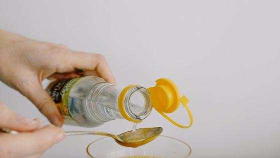 Женщина наливает уксус в ложку Женщина наливает уксус в ложку