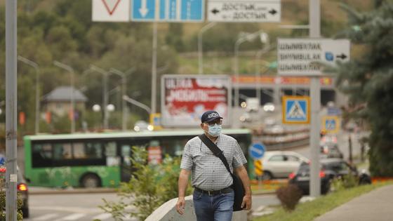 Люди в масках идут по улице Люди в масках идут по улице