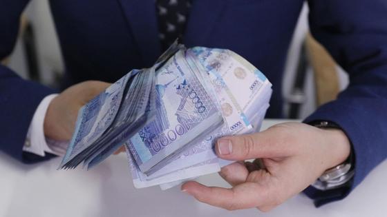 Мужчина в пиджаке держит в руках деньги Мужчина в пиджаке держит в руках деньги