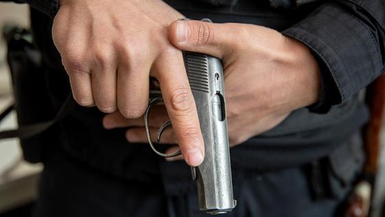 Мужчина держит в руках пистолет Мужчина держит в руках пистолет
