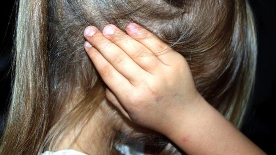 Девочка закрывает уши руками Девочка закрывает уши руками