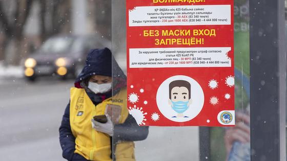 Женщина смотрит в телефон на остановке Женщина смотрит в телефон на остановке