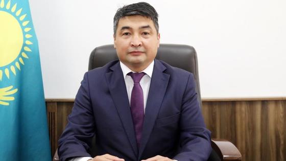 Асет Калиев сидит за рабочим столом Асет Калиев сидит за рабочим столом