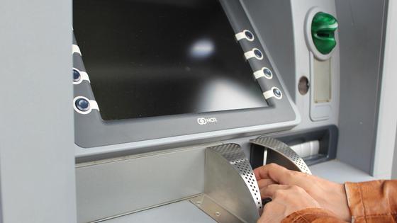 мужчина стоит возле банкомата мужчина стоит возле банкомата