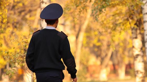 Полицейский идет по улице осенью Полицейский идет по улице осенью