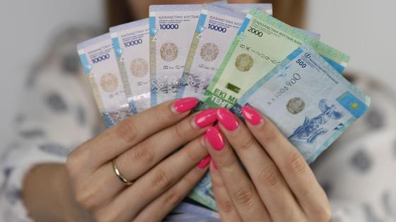 девушка держит в руках 42,5 тыс. тенге девушка держит в руках 42,5 тыс. тенге