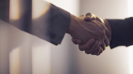 Двое мужчин жмут друг другу руки Двое мужчин жмут друг другу руки