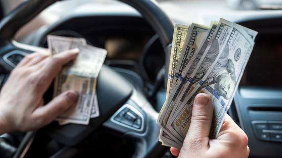 Водитель авто считает деньги Водитель авто считает деньги