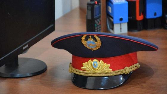 Полицейская фуражка лежит на столе Полицейская фуражка лежит на столе
