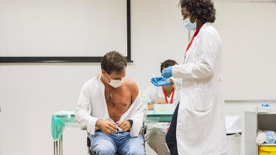 Врач ставит вакцину мужчине Врач ставит вакцину мужчине