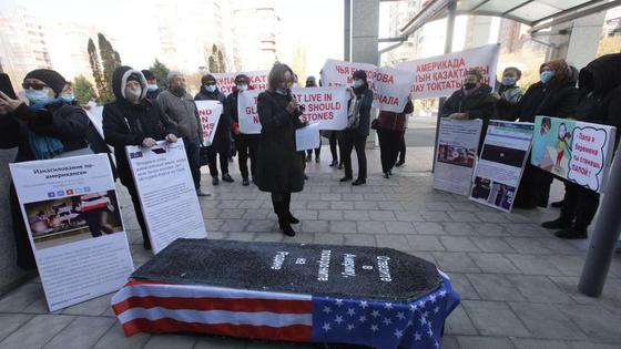 Люди с плакатами собрались вокруг гроба Люди с плакатами собрались вокруг гроба