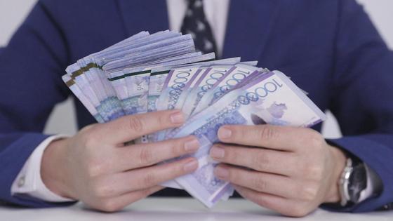 Мужчина держит в руках крупную сумму денег Мужчина держит в руках крупную сумму денег
