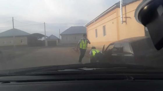 Двое полицейских задерживают водителя автомашины Двое полицейских задерживают водителя автомашины