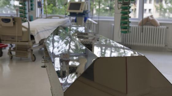Гроб стоит в больничной палате на фоне койки Гроб стоит в больничной палате на фоне койки