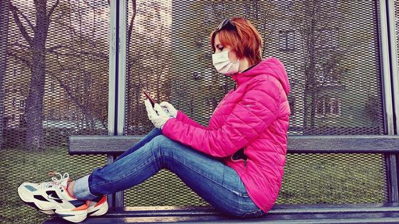 Девушка сидит с телефоном на лавочке Девушка сидит с телефоном на лавочке