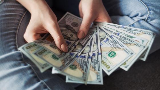 Купюры по 100 долларов в руках Купюры по 100 долларов в руках