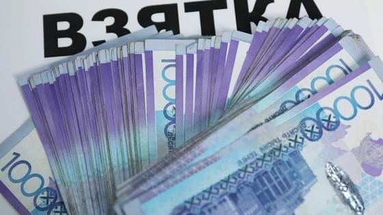 купюры тенге лежат на надписи "взятка" купюры тенге лежат на надписи "взятка"