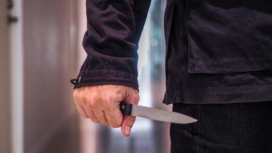 Мужчина стоит с ножом в руке Мужчина стоит с ножом в руке