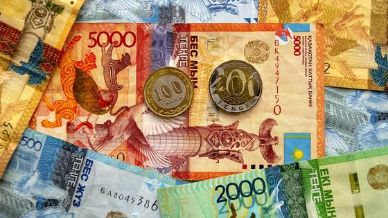 Монеты тенге лежат на купюрах тенге Монеты тенге лежат на купюрах тенге