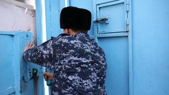Сотрудник СИЗО закрывает дверь Сотрудник СИЗО закрывает дверь