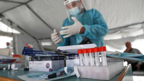 Мужчина в костюме медика снимает перчатку Мужчина в костюме медика снимает перчатку