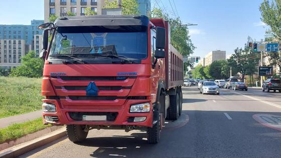 Красный самосвал стоит у обочины дороги Красный самосвал стоит у обочины дороги