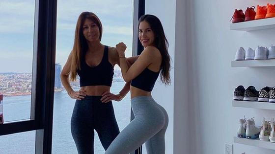 Мать и дочь у окна в фитнес-костюмах Мать и дочь у окна в фитнес-костюмах