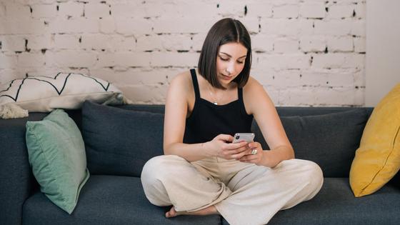 Девушка со смартфоном на диване Девушка со смартфоном на диване
