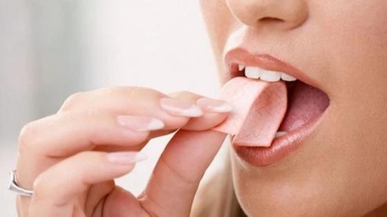 девушка кладет в рот жвачку девушка кладет в рот жвачку