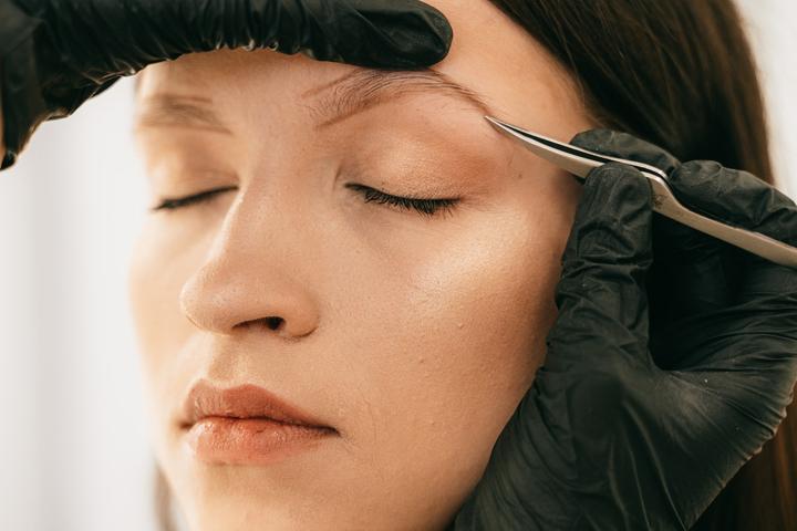 Девушке рисуют и подщипывают брови Девушке рисуют и подщипывают брови